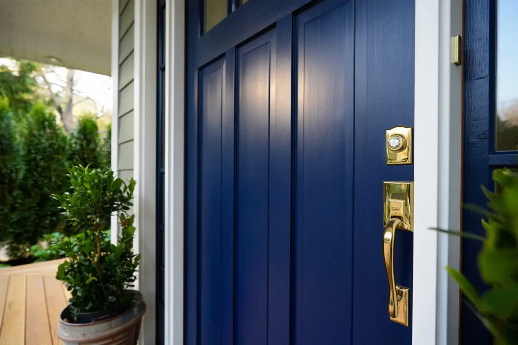 Angled close-up of a freshly painted navy blue front door with a semi gloss finish and polished brass hardware.