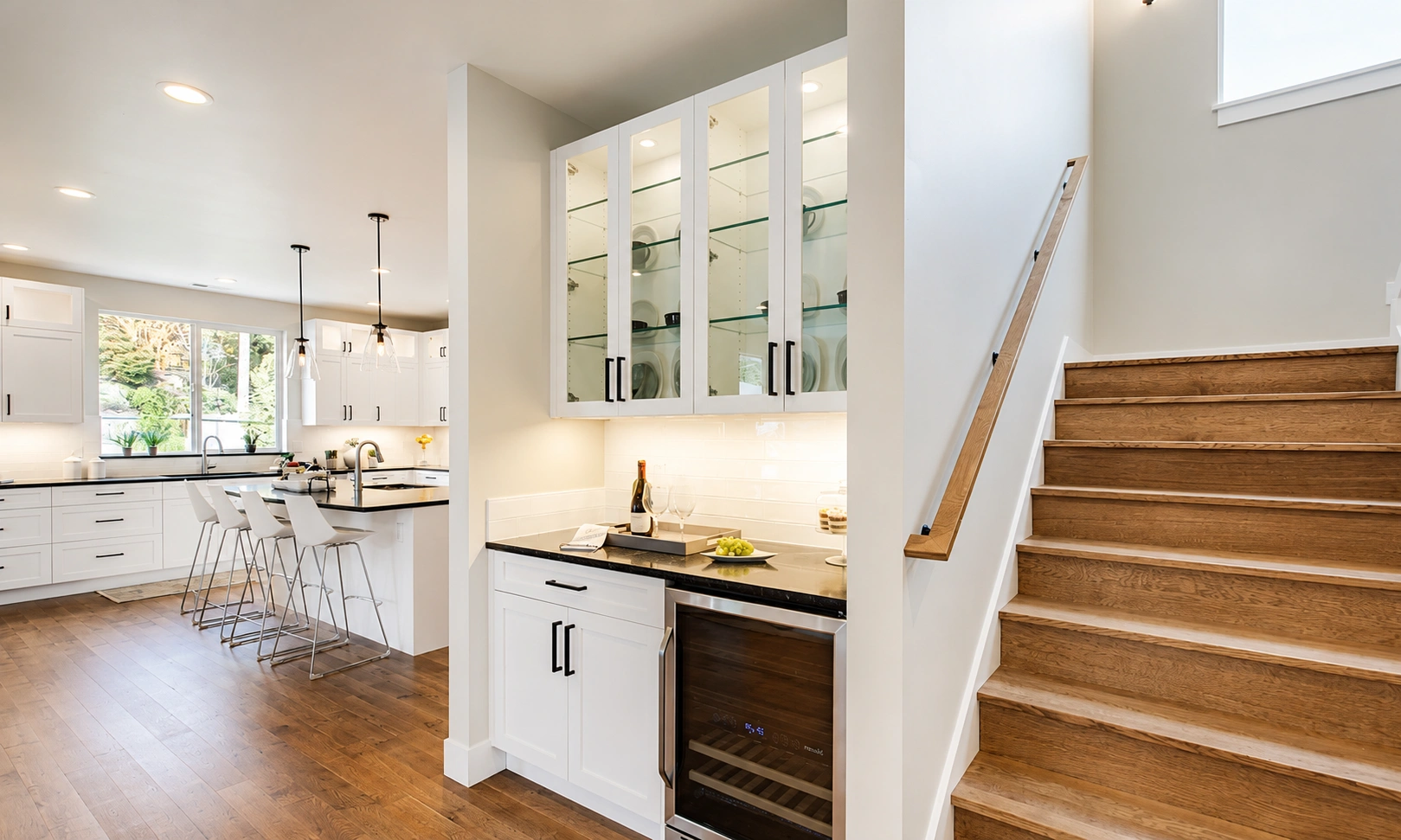 White kitchen cabinets and wooden stairs enhanced by a professional house painter Mercer Island.
