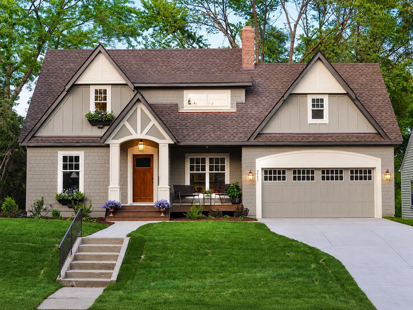Gray craftsman home exterior with white trim, wood door, and garage