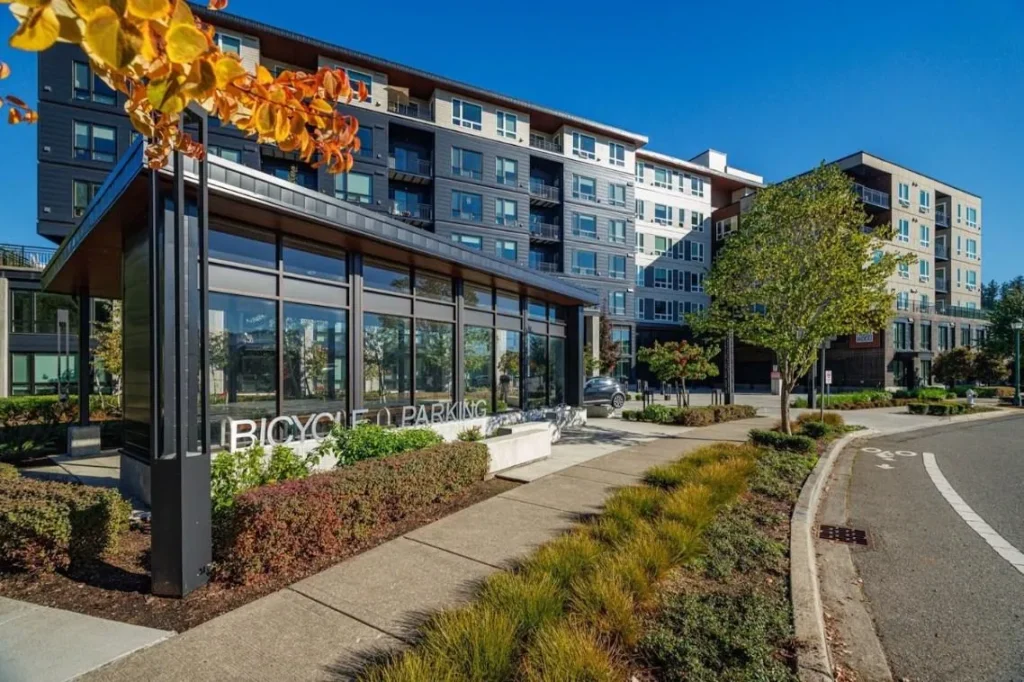Apartment exterior with contrasting gray siding, light upper panels, and recessed balconies in Issaquah, WA.